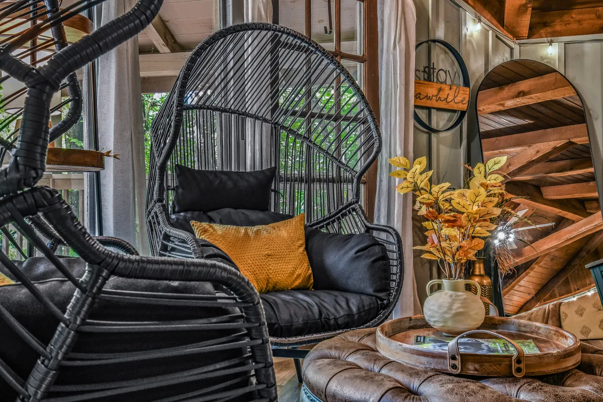 This cozy social nook features a hanging chair, colorful cushions, and a wooden coffee table, all set in an inviting, open space. The decor evokes relaxation and togetherness, with soft lighting suggesting a laid-back afternoon or evening gathering.