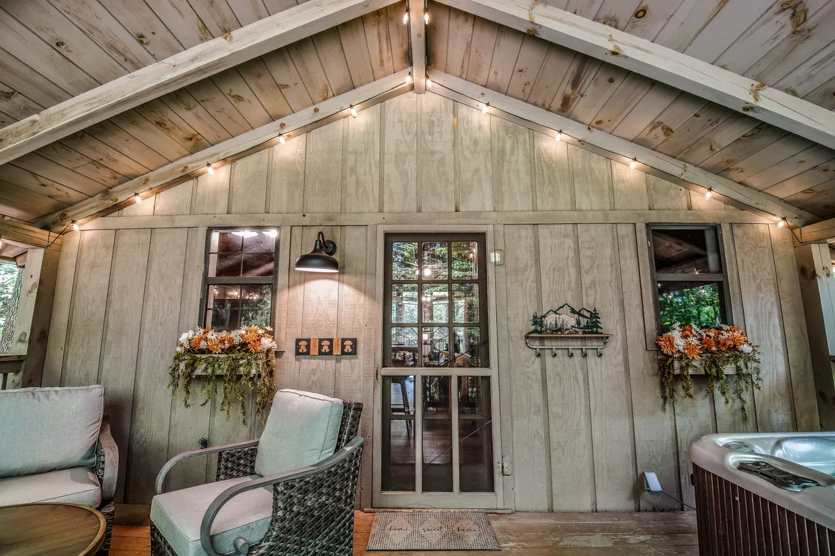 A welcoming entryway highlighted by a glass-panel door, tasteful wall art, and a glimpse into a serene seating area with a hot tub. The space is designed for easy, step-free access, setting a positive first impression for arriving guests.